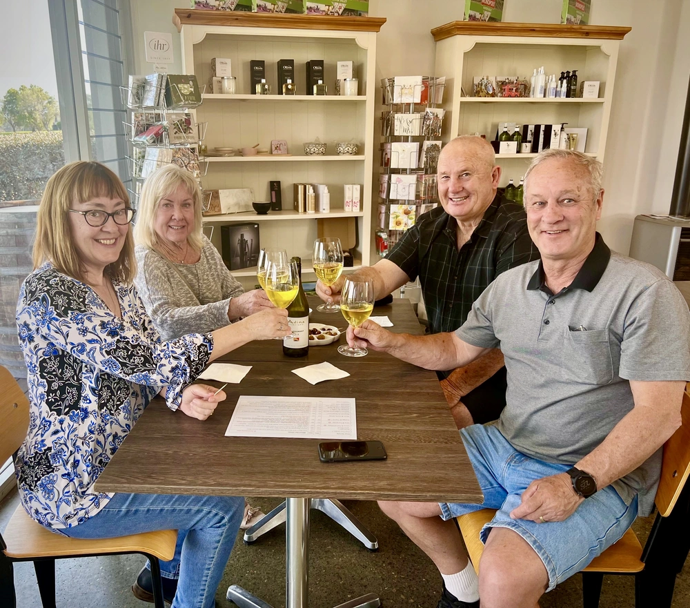 Customers enjoying a wine tasting at Adina Vineyard and Olive Grove2 A group of 4 customers are seated at a table enjoying a wine tasting at the Cellar Door at Adina Vineyard and Olive Grove.